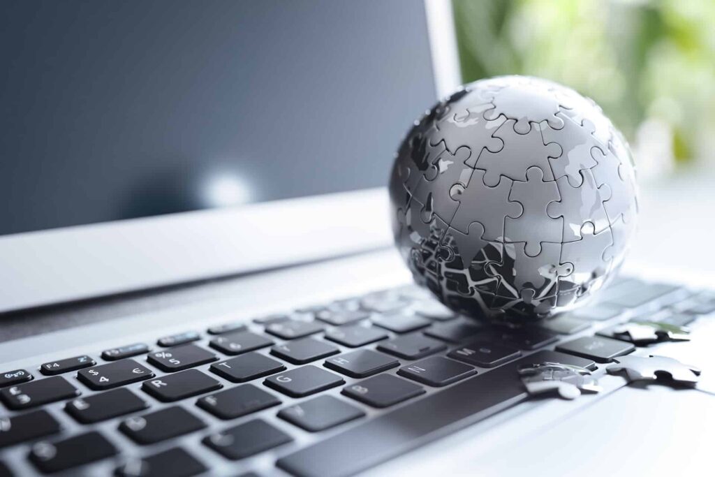 een wereldbol uit puzzelstukjes op een laptop toetsenbord